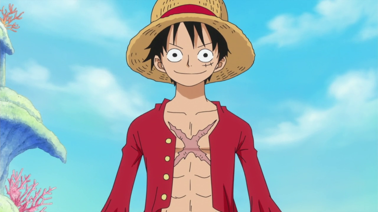 Luffy, tem um chapéu de palha com uma fita vermelha, cabelos pretos, usa uma blusa vermelha aberta, e possui uma cicatriz no peito no formato de um x